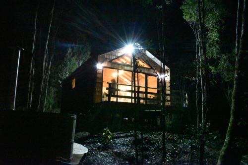 a wooden cabin in the woods at night at Puente Palos San Pedro in Castro