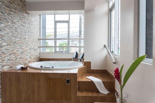baño con bañera y ventana en Hotel Monte Cafeto INN, en Pichanaki