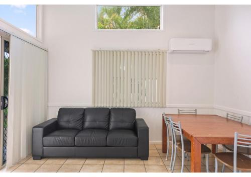 a living room with a black couch and a table at Discovery Parks - Coolwaters, Yeppoon in Kinka