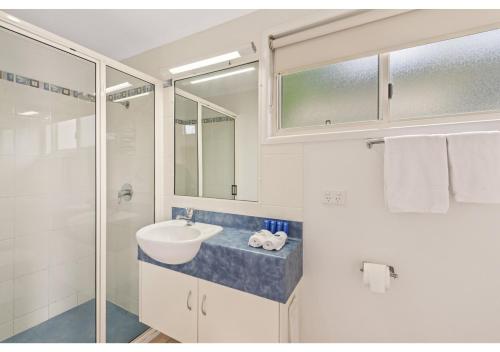 a white bathroom with a sink and a shower at Discovery Parks - Coolwaters, Yeppoon in Kinka
