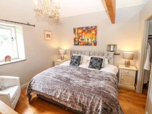 a bedroom with a bed and a chandelier at Wortley Barn in Bradwell