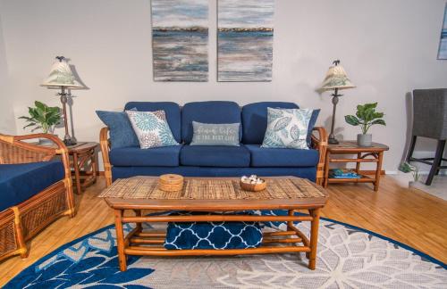 a living room with a blue couch and a table at Molokai Island Retreat with Beautiful Ocean Views and Pool - Newly Remodeled! in Ualapue