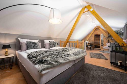 um quarto com uma cama e uma sala de estar em Select-Home 1 - Wellnesshaus Sandmühle - mit privater Sauna em Bruck in der Oberpfalz
