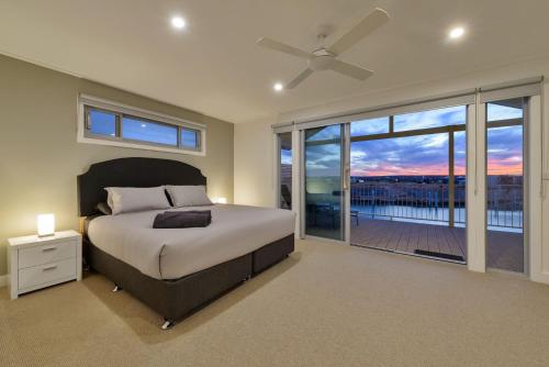 1 dormitorio con cama y vistas a un balcón en 108 Madaffari Drive, en Exmouth
