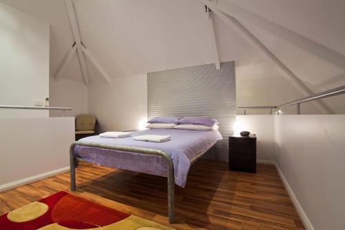エクスマウスにあるOsprey Holiday Village Unit 103 2 Bedroomのベッドルーム1室(紫のシーツとラグが入ったベッド1台付)