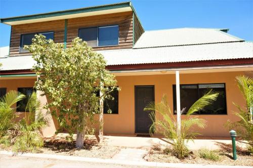 a house with a tree in front of it at Ningaloo Breeze Villa 3 in Exmouth
