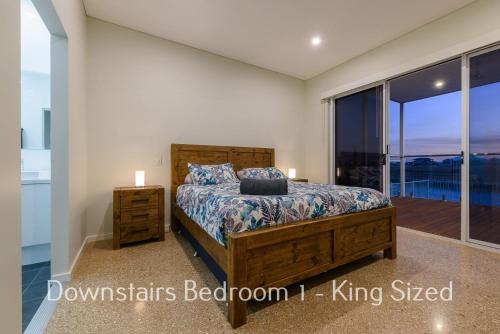 a bedroom with a bed and a balcony at 32 Corella Court in Exmouth
