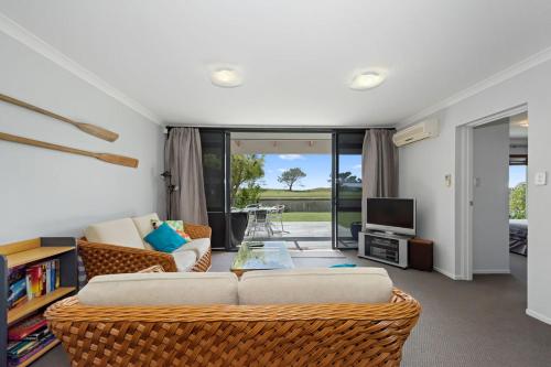 a living room with two couches and a television at The Sandcastle - Papamoa Holiday Apartment in Papamoa