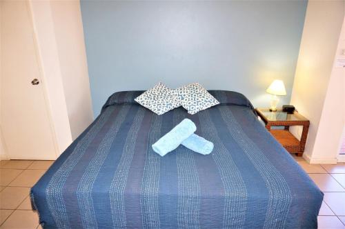 Una cama azul con dos corbatas de lazo. en Osprey Holiday Village Unit 201 1 Bedroom en Exmouth