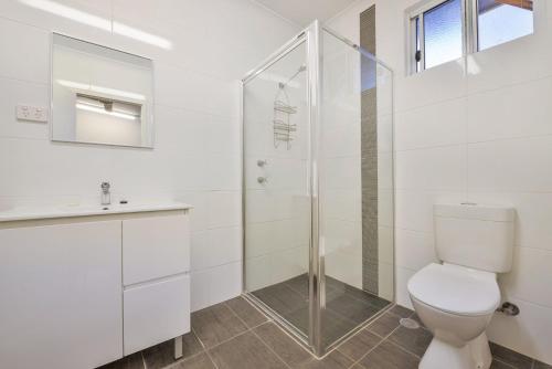 a white bathroom with a toilet and a shower at Getaway Villas Unit 3811 in Exmouth