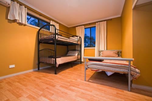 2 Etagenbetten in einem Zimmer mit gelben Wänden in der Unterkunft 9 Skipjack Circle in Exmouth