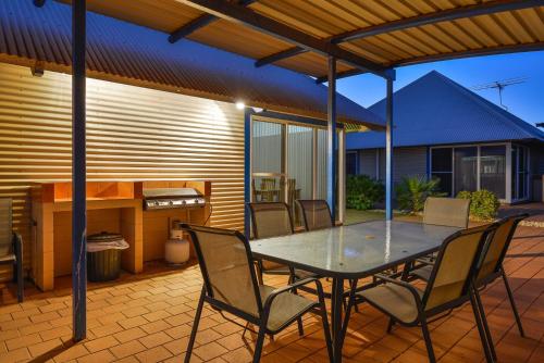 a patio with a table and chairs on a patio at Osprey Holiday Village Unit 117 in Exmouth