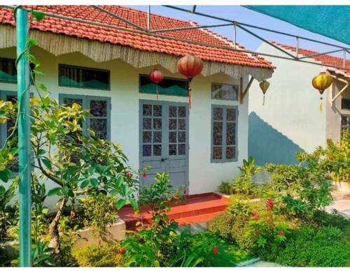 een klein wit huis met een rood dak bij Hang Mua Happiness Homestay in Ninh Binh