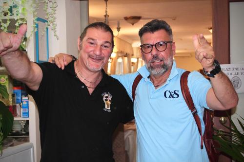 two men are standing next to each other at Hotel Tahiti in Viareggio