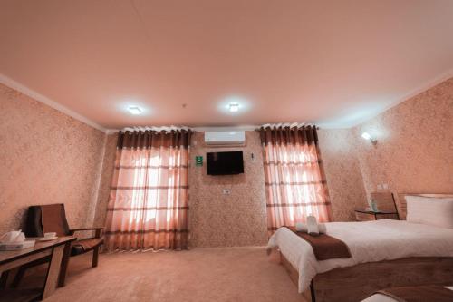 a hotel room with a bed and a television at Reikartz Kokand in Kokand