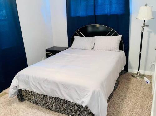 a bedroom with a white bed with a black headboard at CHERRY STREET LUXURY- SHOPPING-DINING-BY DOWNTOWN AND HOSPITALs in Tulsa