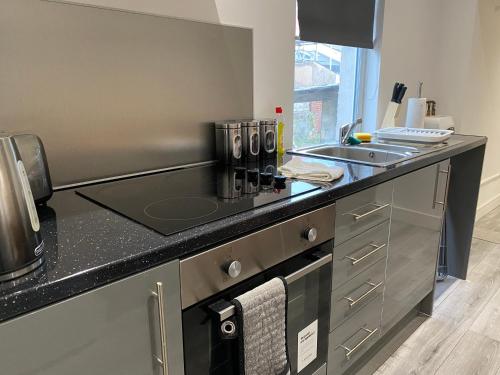 a kitchen with a sink and a counter top at Cosy 2 Bed Flat 1 in Bridgend in Bridgend