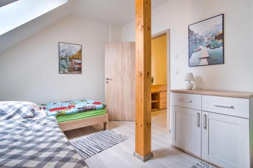 a small bedroom with a bed and a desk at Rezidence Podkova in Frymburk