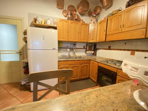 una cucina con armadi in legno e frigorifero bianco di Maison Coppola a Vico Equense