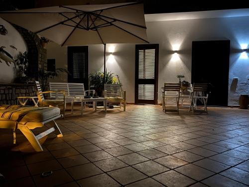 a room with tables and chairs and an umbrella at Maison Coppola in Vico Equense