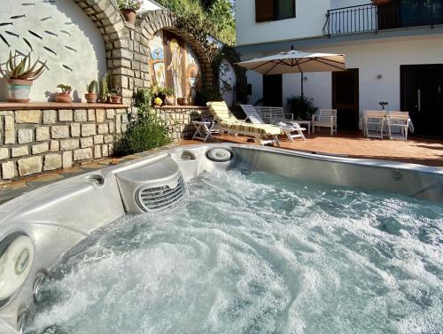 una vasca immersione ad acqua fredda con idromassaggio in un cortile con patio di Maison Coppola a Vico Equense