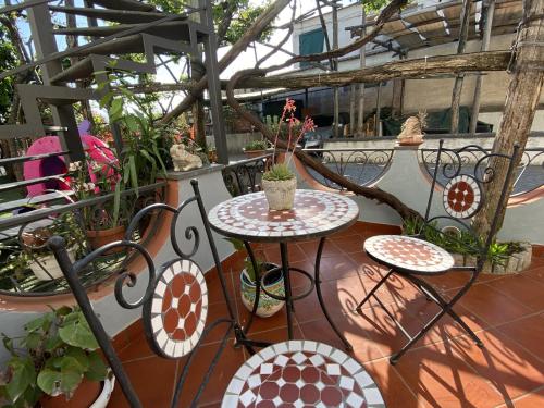 a patio with a table and chairs and plants at Maison Coppola in Vico Equense
