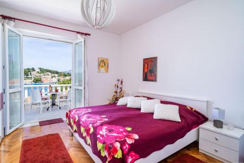 1 dormitorio con 1 cama grande y balcón en Apartments Mara & Petrunjela, en Cavtat