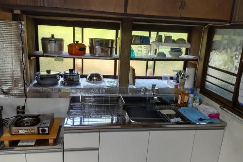 a kitchen with a sink and a stove at 古民家リゾートハウス　ひみつきち in Kakegawa