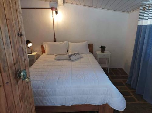 a bedroom with a white bed with two pillows at Κυμοθόη in Milopotamos