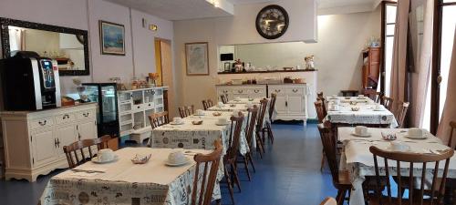 a dining room with tables and chairs and a clock at H&ocirc;tel du Palais in &Eacute;vian-les-Bains