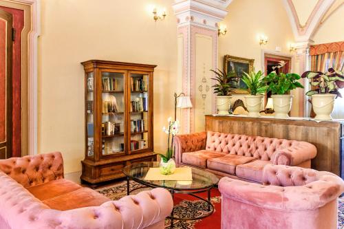 a living room with pink couches and a table at Hotel Villa San Michele in Lucca