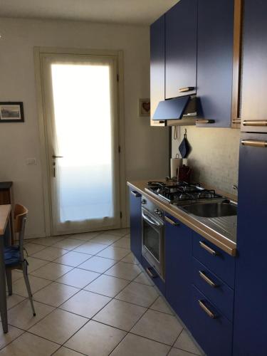 CASA EZZELINA في Romano D'Ezzelino: مطبخ مع دواليب زرقاء وفرن علوي موقد