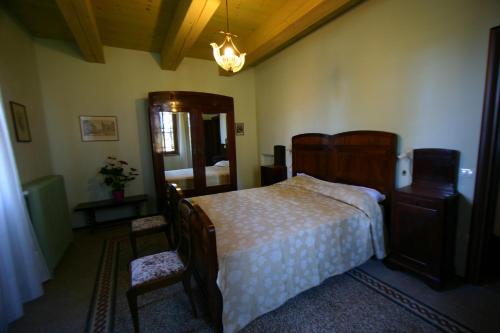 a bedroom with a bed and a dresser and chair at Locanda Donna Laura in Imola