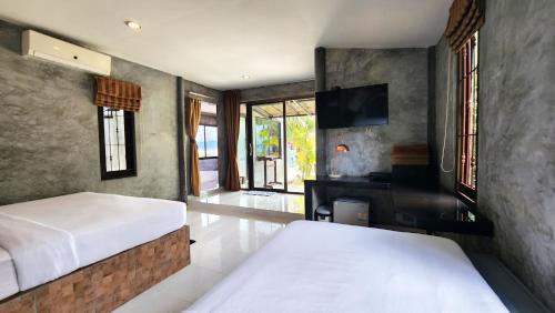 a hotel room with a bed and a tv at Sabaii Bay Resort in Ban Tai