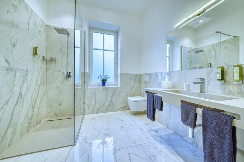 a bathroom with a shower and a sink and a toilet at Villa Tell rooms and suites in Merano