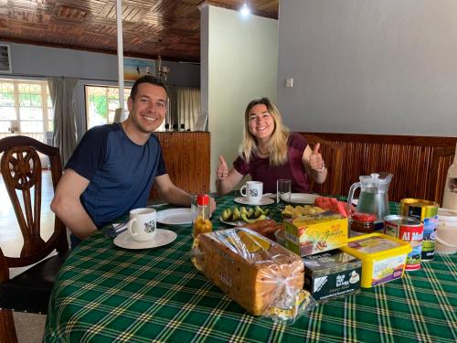 a man and a woman sitting at a table at Pazuri Hostel in Moshi