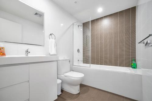 シドニーにあるKOZYGURU Parramatta Lovely 2 BED APT Free Parking NPA006の白いバスルーム(トイレ、バスタブ、シンク付)