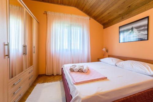 - une chambre avec un lit et 2 serviettes dans l'établissement Apartments Juracak, à Nin