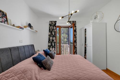 Un dormitorio con una gran cama rosa con almohadas. en Apartman MaRiTo en Selca