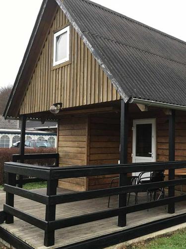 a log cabin with a bench on a deck at Løgstør Camping in Løgstør