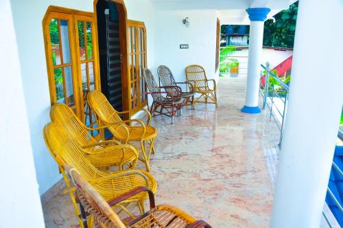 a group of yellow chairs sitting on a porch at Gilead Holliday in Tāmarakulam
