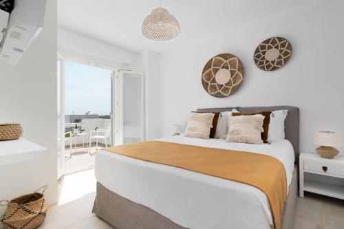 een witte slaapkamer met een groot bed en een balkon bij Pyrgaki Beach Villa in Aliko Beach