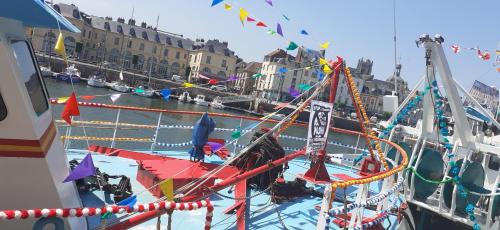 un bateau est amarré dans un port aux pavillons dans l'établissement Maison d'Hôtes Archangels Home, à Saint-Saëns