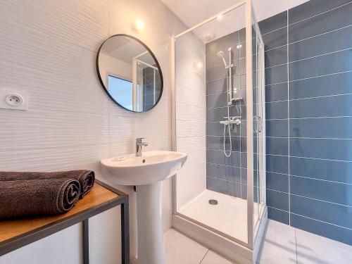une salle de bain avec un lavabo et une douche avec un miroir dans l'établissement Chez Lisa-Maison de ville à Concarneau, à Concarneau