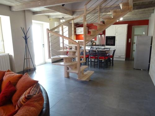 een woonkamer met een wenteltrap en een keuken bij Gîte Les Paredous in Broquiès