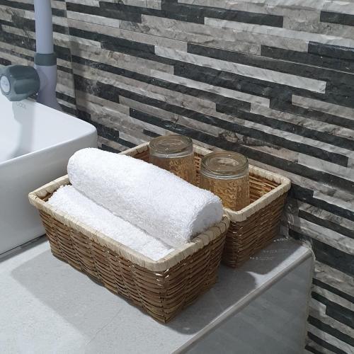 a bathroom with two baskets of towels and a sink at Sapphire Boutique Resort in Panglao Island
