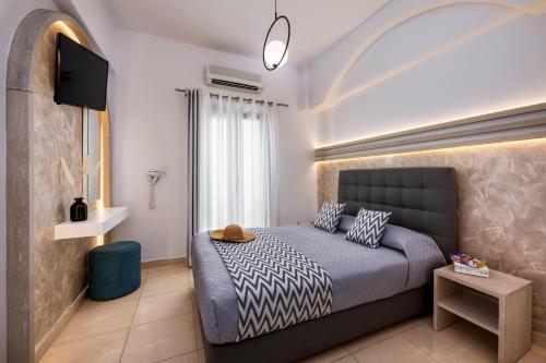 a bedroom with a bed and a flat screen tv at Petros Villa in Fira