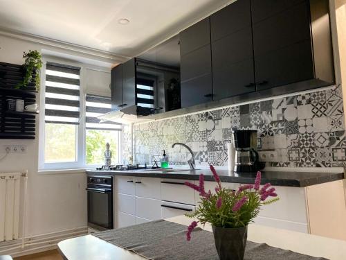 a kitchen with black cabinets and a vase with flowers at Central Crib in Hunedoara