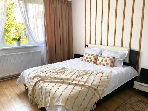 a bedroom with a bed with a striped headboard and pillows at Central Crib in Hunedoara