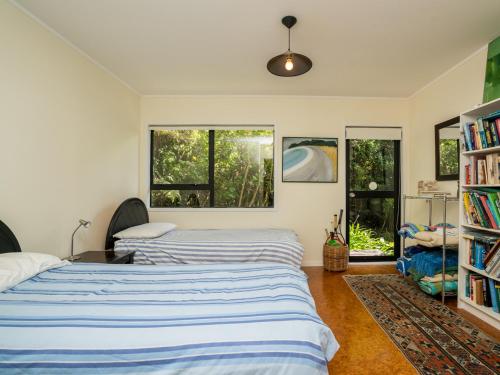 2 Betten in einem Zimmer mit 2 Fenstern in der Unterkunft Langs Hideaway - Langs Beach Holiday Home in Langs Beach